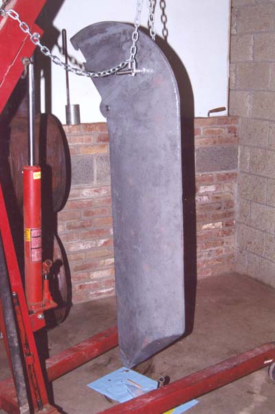 The keel hanging from an engine hoist, partially refurbished
